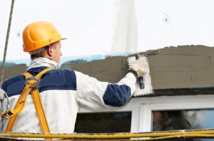 Tradesman at plastering a wall